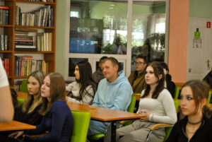 osoby siedzą w ławkach