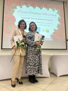 dwie osoby stoją na tle ekranu