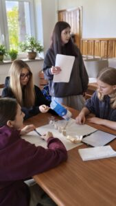 osoby siedzą przy ławkach w sali