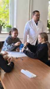 osoby wykonują przy stole doświadczenia