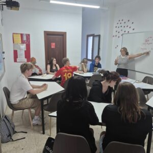 osoby siedzą w sali i uczą się 