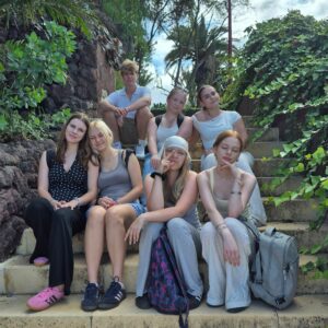 grupa osób siedzi na schodach